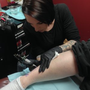 Jaime Haught, of Broadwing Tattoo, starts inking on Mellisa Marshall's ankle.