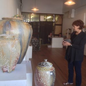 Mary Kronberg looks at pots at the BGSU ceramics sale.