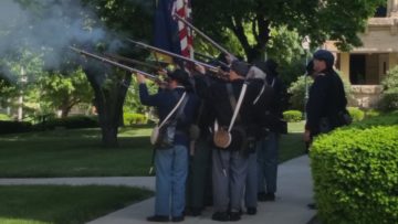 Civil War re-enactors fire salute at county courthouse.