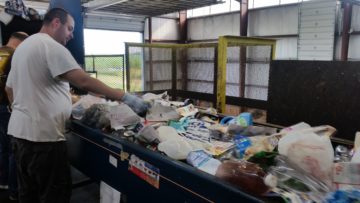 Jamie Babcock, of Community Employment Services, sorts through recyclables mixed with trash.