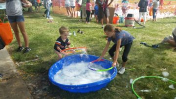Children create giant bubbles.
