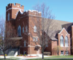 Church building with bare trees and blue sky