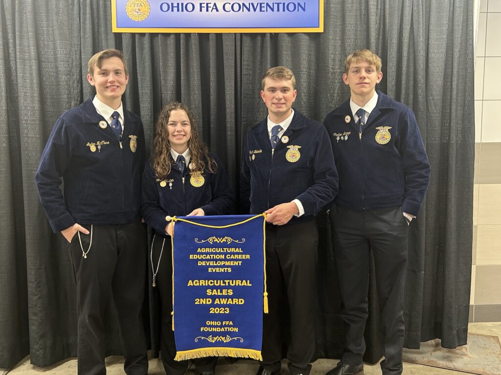 Otsego FFA members hold Agricultural Sales 2nd Award banner