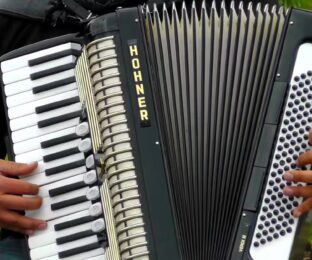 accordion and right hand on keyboard and left hand on bass buttons.