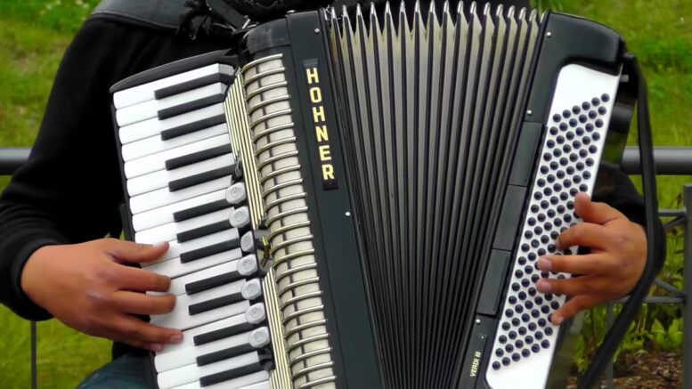 accordion and right hand on keyboard and left hand on bass buttons.