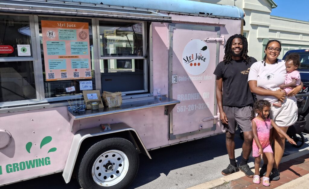 The Meyers family standing in front of their juice truck.