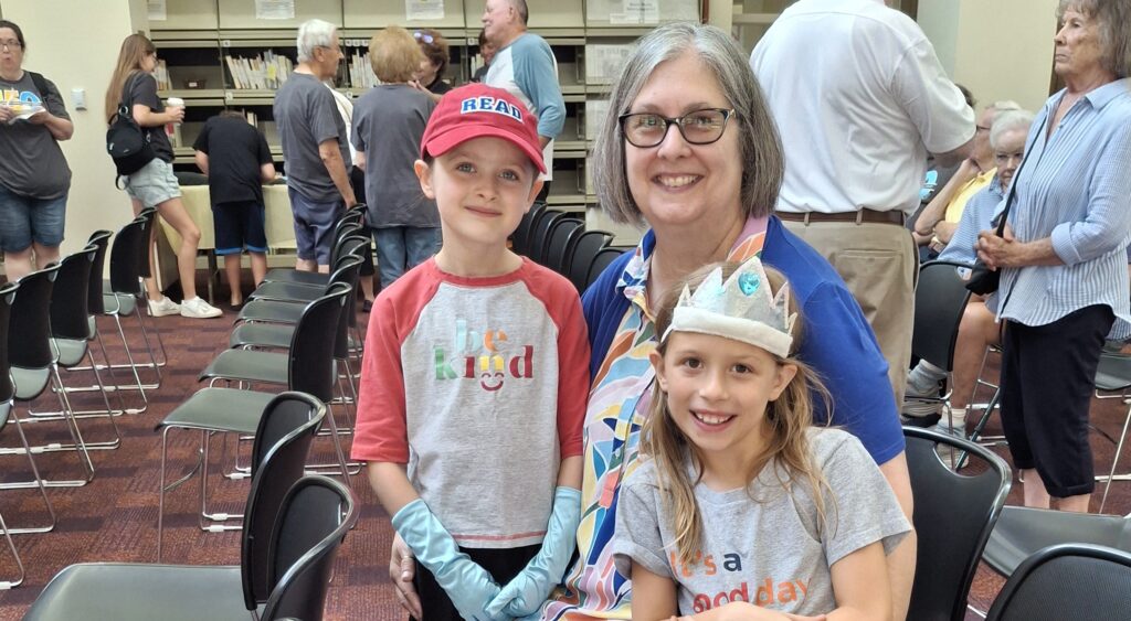 Savannah and Nevea Eames sit on the lap of deputy director Michele Raine.
