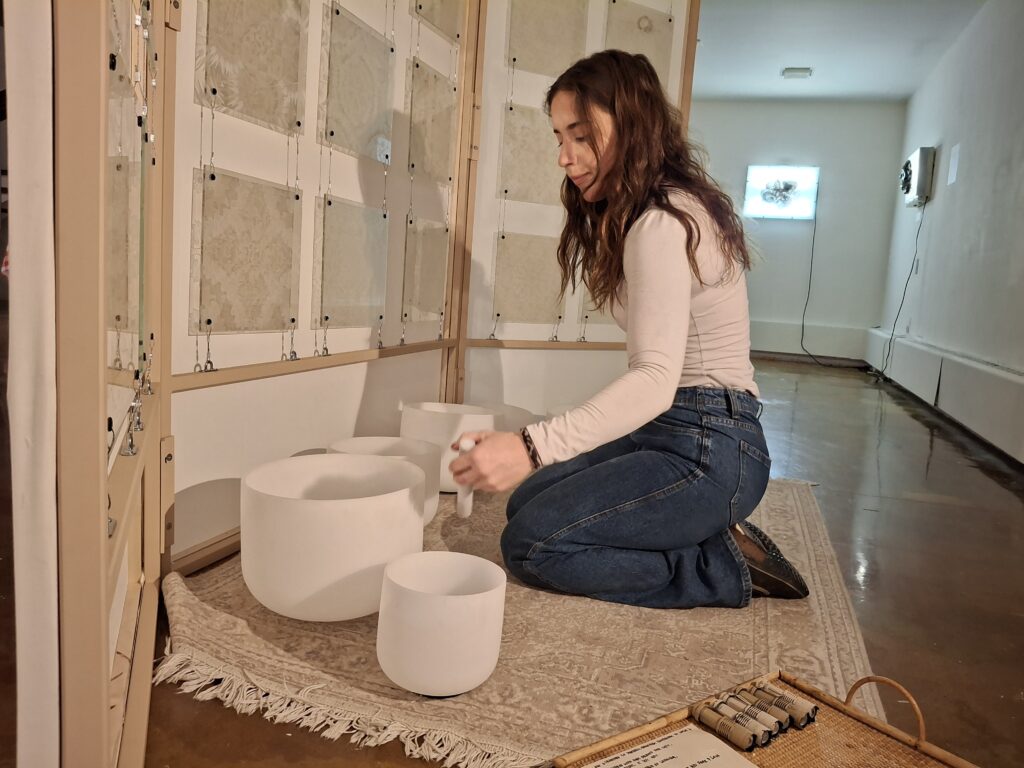 Sophie Pineau plays sound bowls as part of her exhibition.