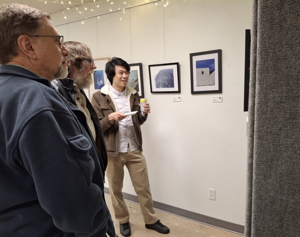 Three men looking at art.