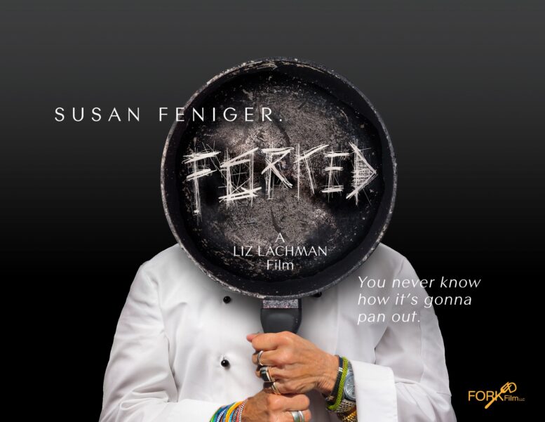 person in chef's uniform uses two hands to hold a cast iron skillet in front of their face. the skillet has the word "forked" etched into it.