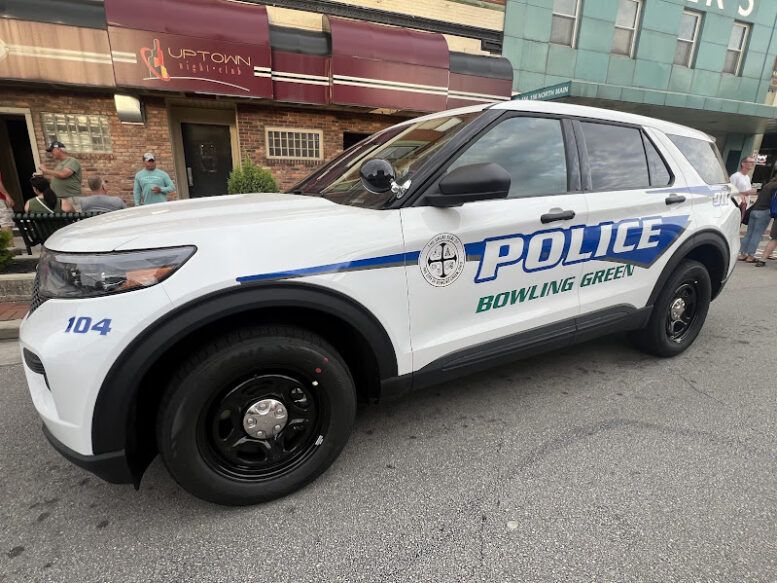 a police car is parked in front of a downtown bar