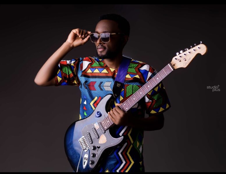 Photo of Sam Shaba holding a guitar.