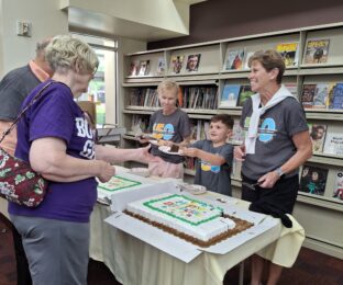 Volunteers serving cake at library birthday party