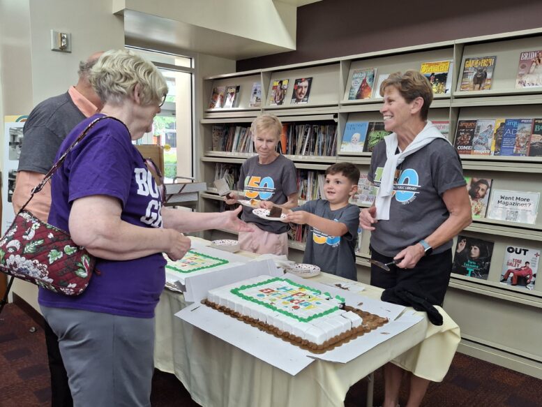 Volunteers serving cake at library birthday party