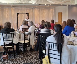 Audience members at the Women in Business luncheon listen to Jessica Miller-Blakely speak.